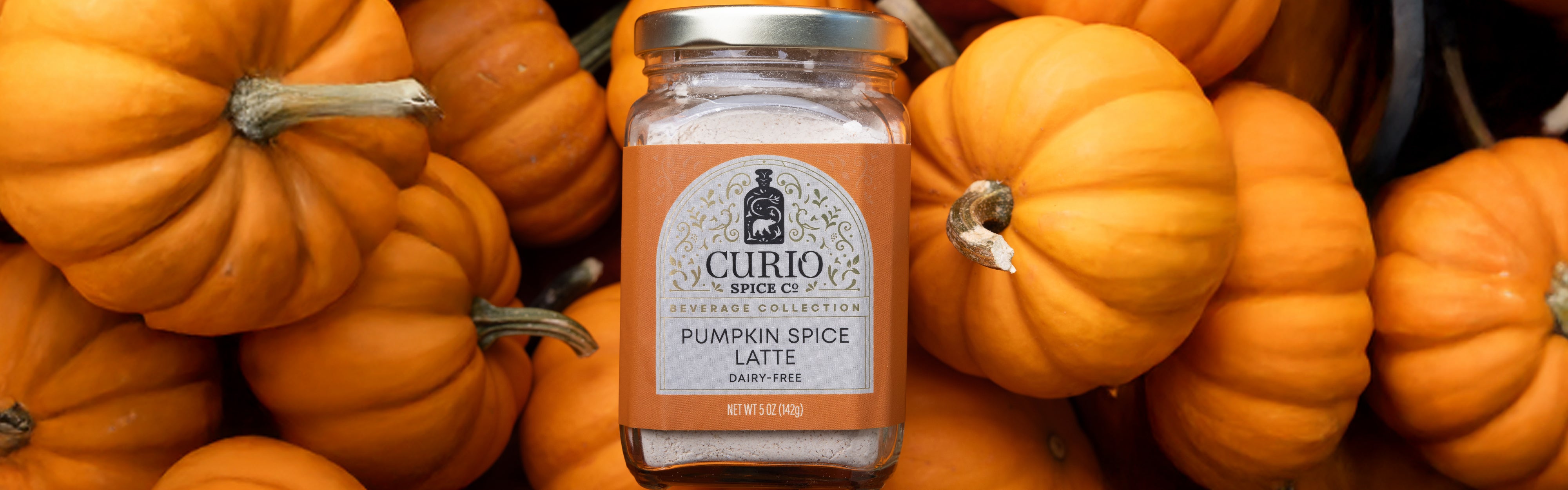 Jar of pumpkin spice latte mix surrounded by pumpkins