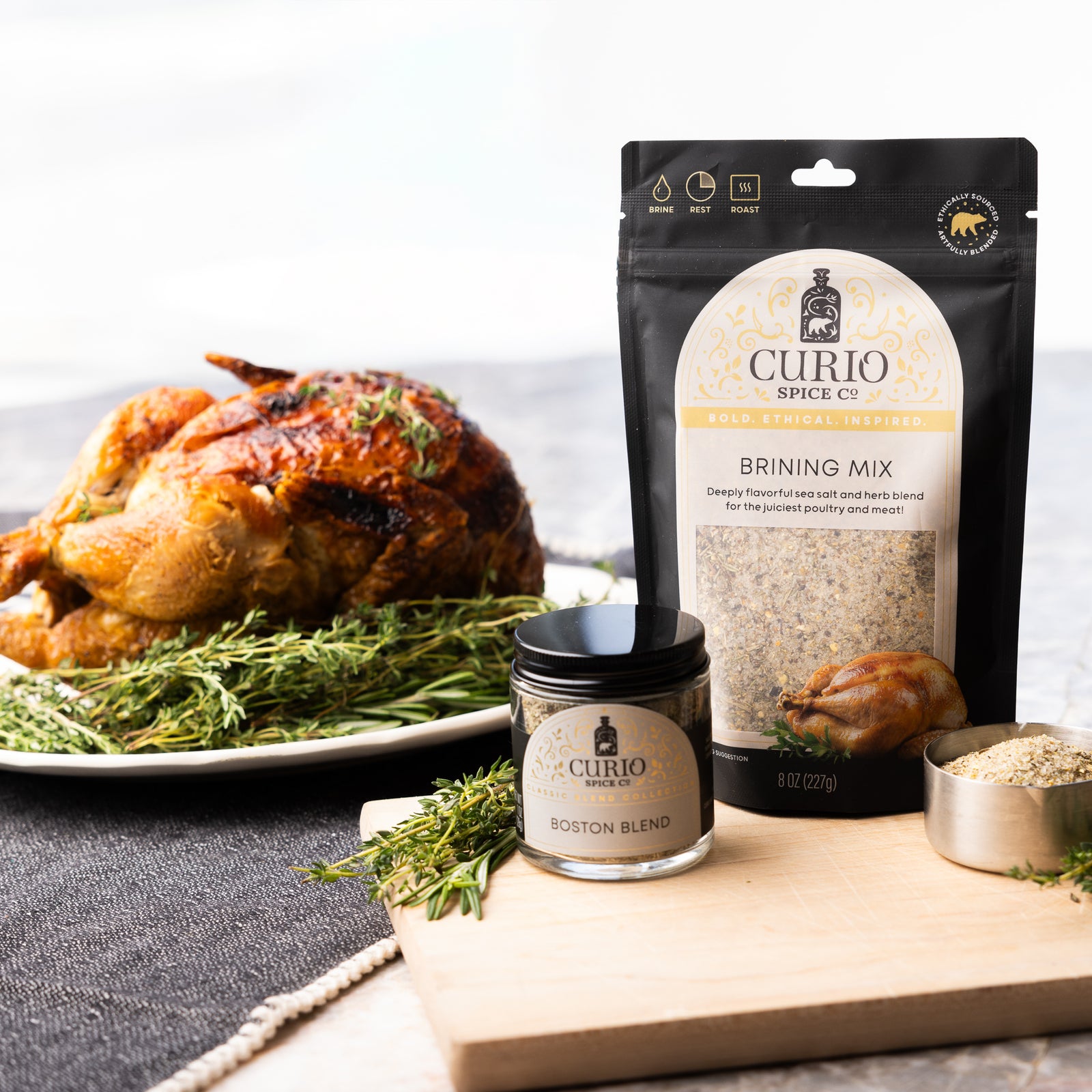 Curio Spice Co. brining mix and Boston blend jar with a roasted turkey on a table.