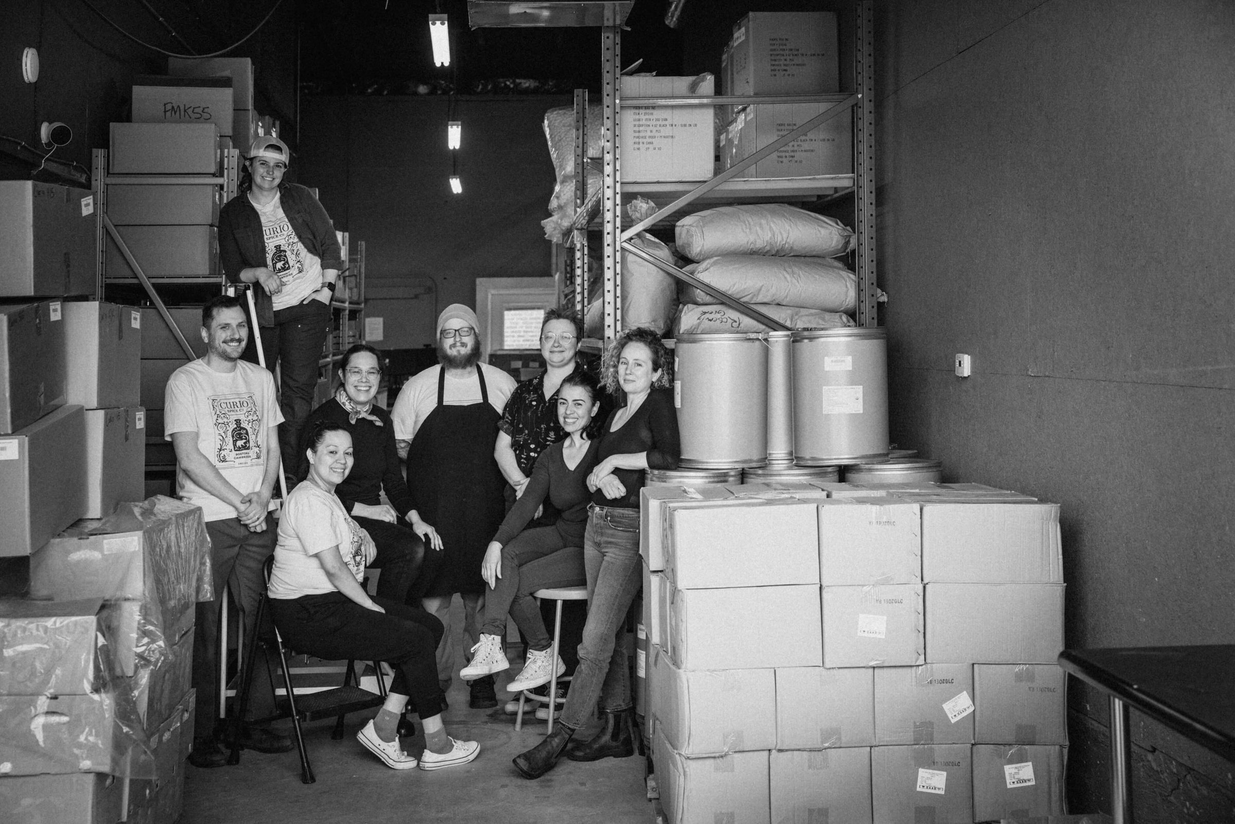Curio Spice Co fulfillment team in a warehouse setting with boxes and equipment.