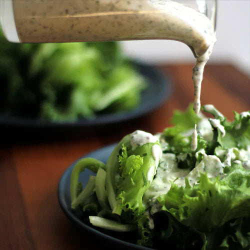 Photo of ranch dressing being poured onto a salad