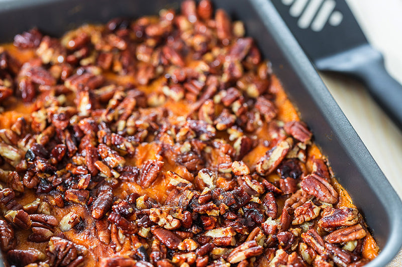 Holiday sweet potato dish topped with pecans.
