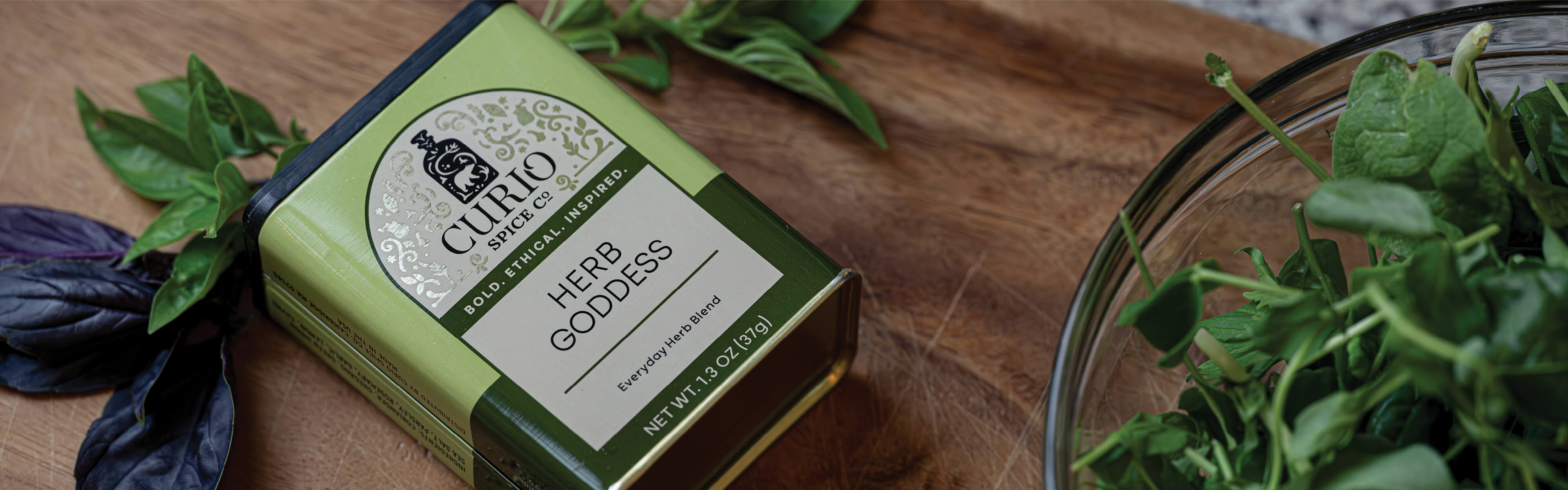 Curio Herb Goddess product on a wooden surface with fresh herbs.