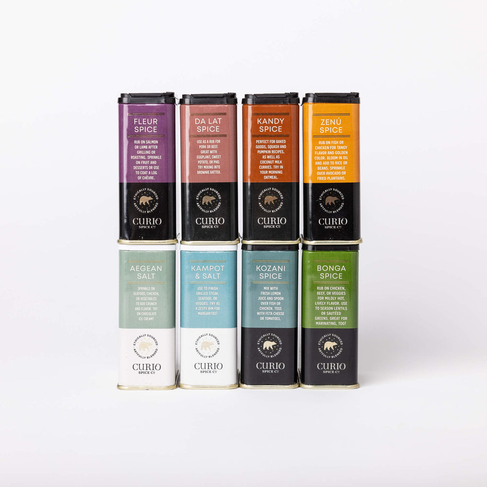 Set of Curio spice and salt containers in various colors on a white background