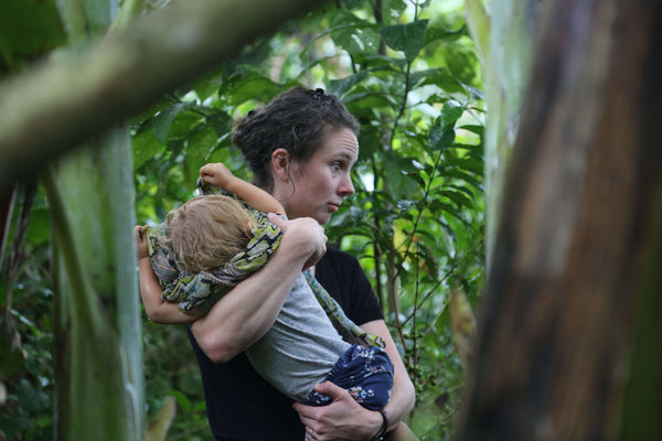 Claire Cheney holding her baby in the jungle in Ethiopia.