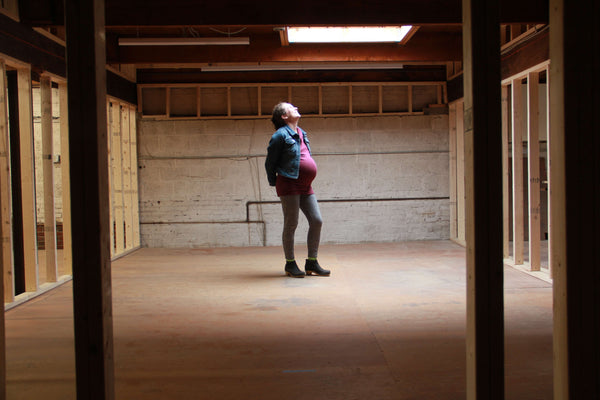 Claire Cheney, pregnant, standing in the new Winchester location as it is under construction.