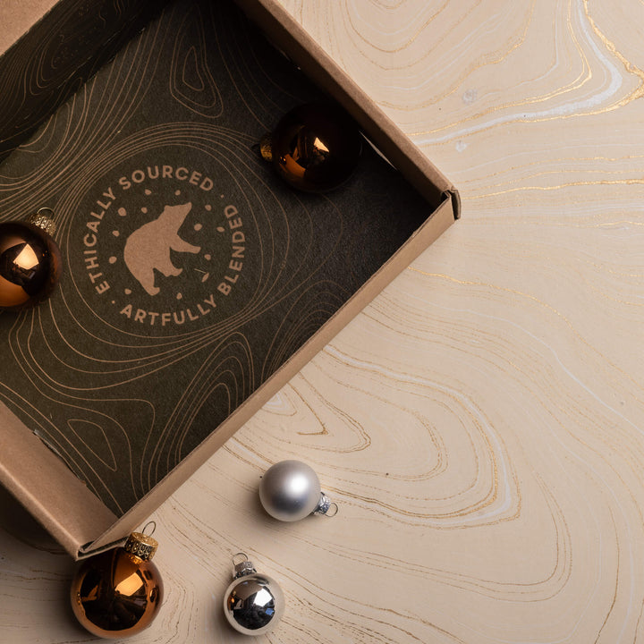 Curio Spice Club box on a marbled background with holiday bulbs. Great for gifting.