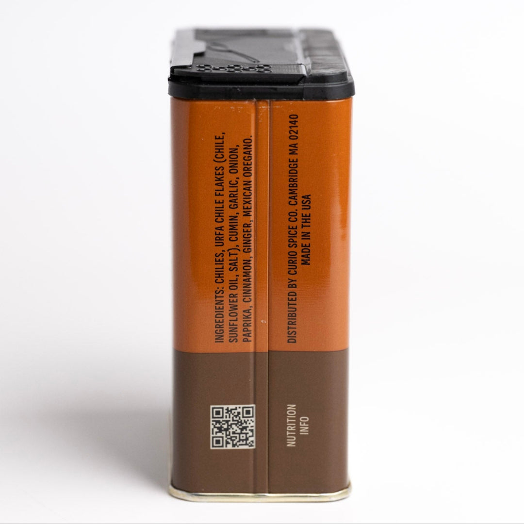 Brown spice container with black lid on a white background