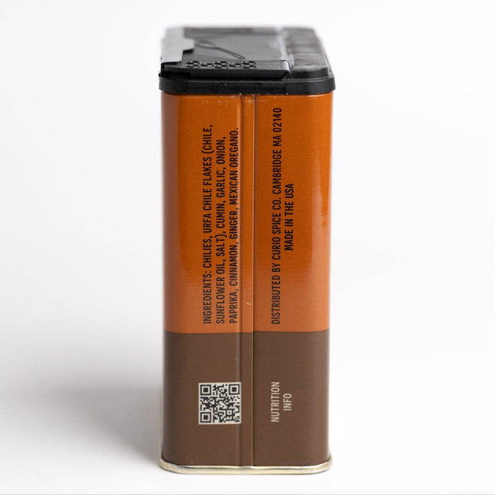 Brown spice container with black lid on a white background