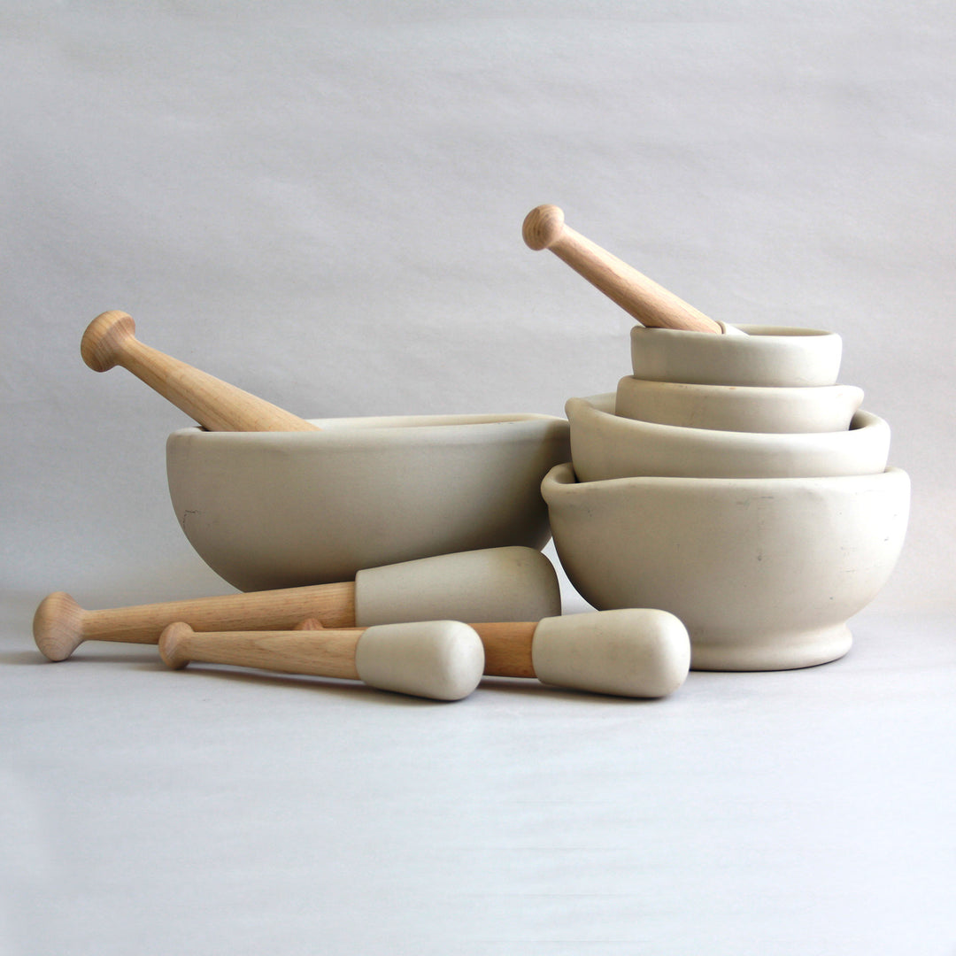 Family of different-sized ceramic mortar and pestles.