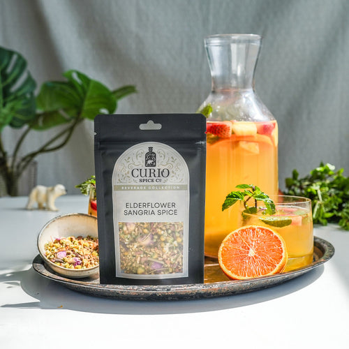 Bag of Elderflower Sangria Spice next to a pitcher of fruited Sangria.