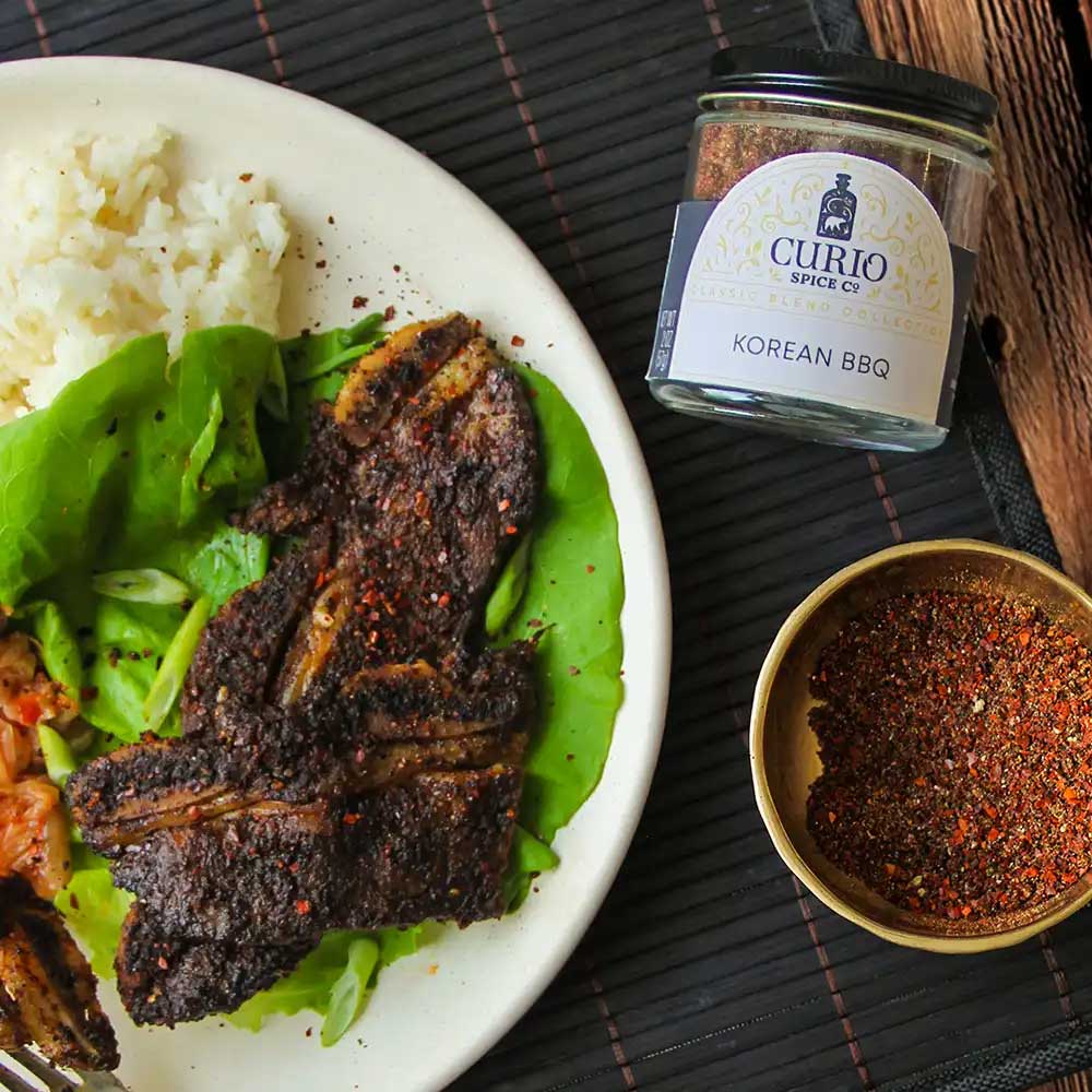Korean BBQ short ribs with rice and lettuce next to a jar of Korean BBQ seasoning