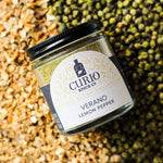 Verano Lemon Pepper jar sitting on a bed of spices used in the blend.