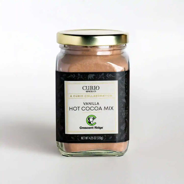 A glass jar of Vanilla Hot Cocoa Mix, a collaboration drink blend with Crescent Ridge and Curio Spice.