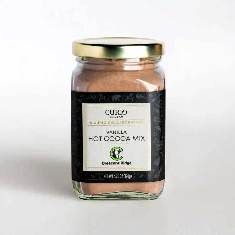 A glass jar of Vanilla Hot Cocoa Mix, a collaboration drink blend with Crescent Ridge and Curio Spice.