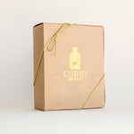 Closed gift box of the 8-Tin Chef Set with a Curio Spice logo and gold ribbon