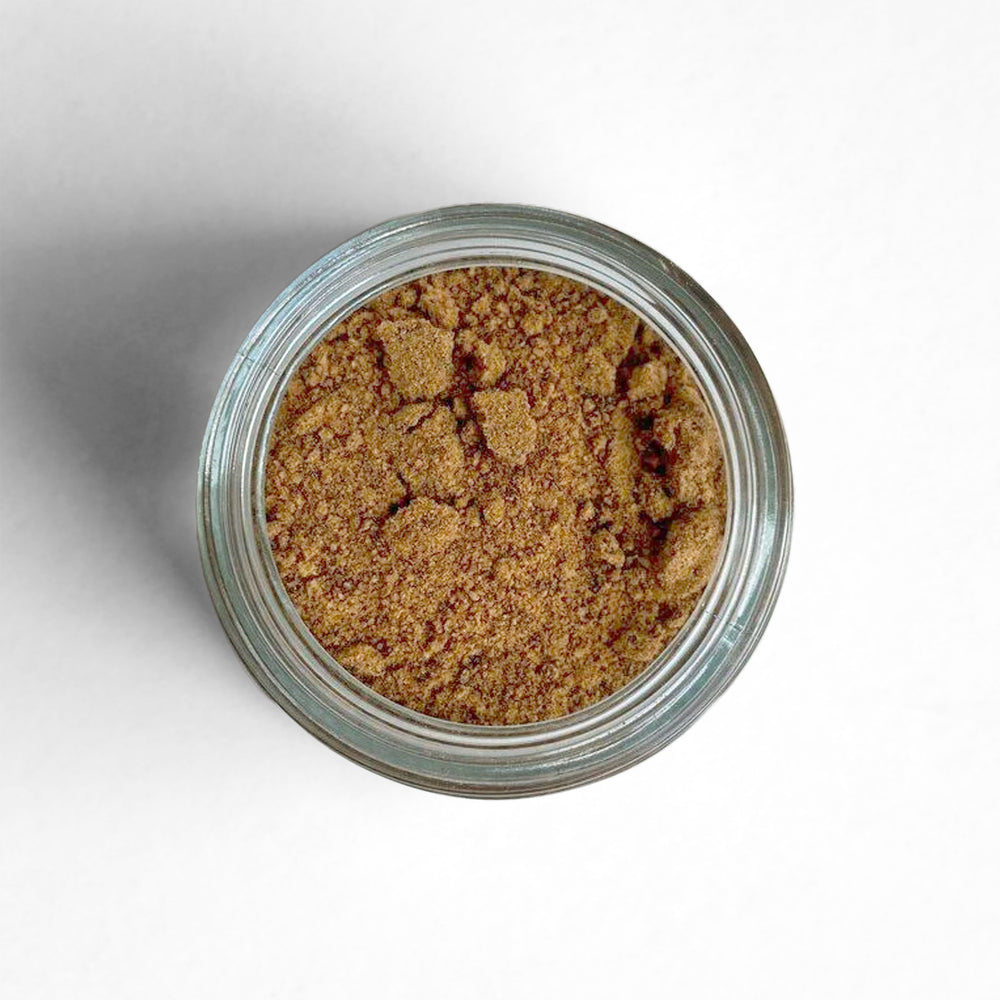 Curio Spice Co. fair-trade single origin sustainable Sri Lankan ground nutmeg in a glass jar from above.
