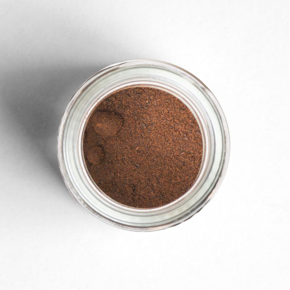Top-down view of Madagascar Vanilla Powder in a glass jar.