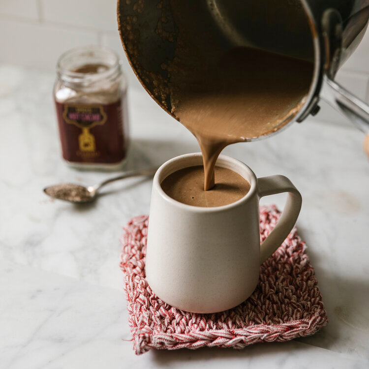 Hot cocoa pouring into a ceramic cup