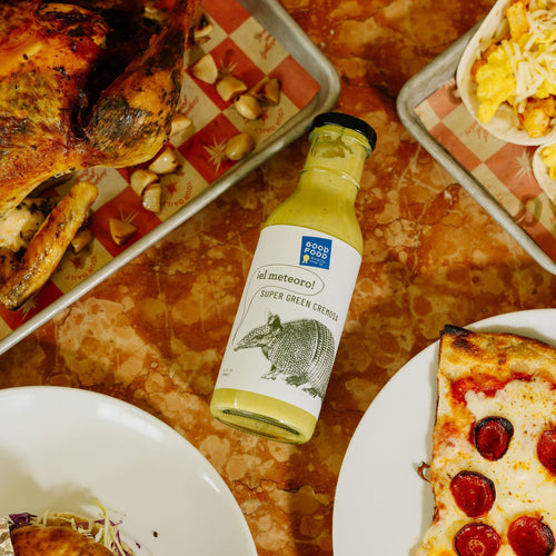 El Meteoro Super Green Cremosa next to pizza and chicken