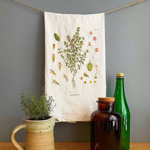 Tea towel with thyme flower against a gray backdrop