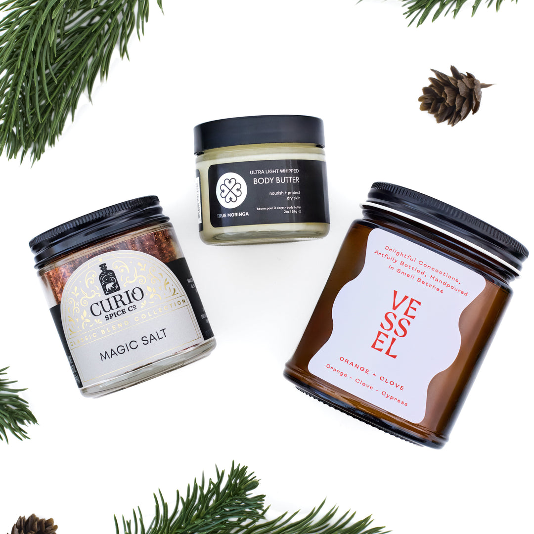 Image of Curio Spice Co Magic Salt jar, True Moringa Body Butter, and Vessel scented candle on a white background with pine needles 