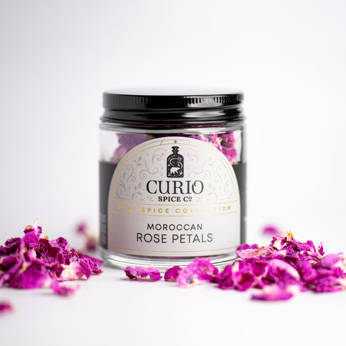 Jar of Moroccan Rose Petals from Curio Spice Co. with pink flowers on a white background