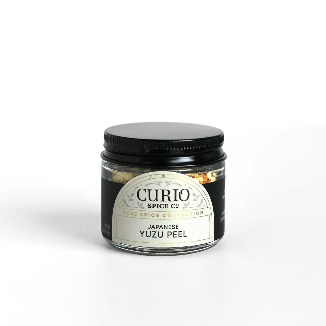 Glass jar filled with Japanese Yuzu Peel showing the Curio Spice logo.
