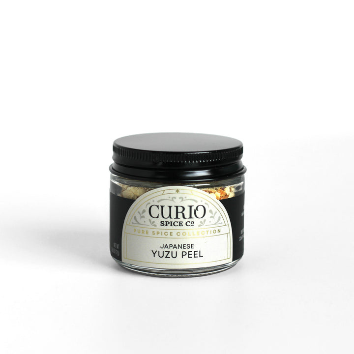 Glass jar filled with Japanese Yuzu Peel showing the Curio Spice logo.