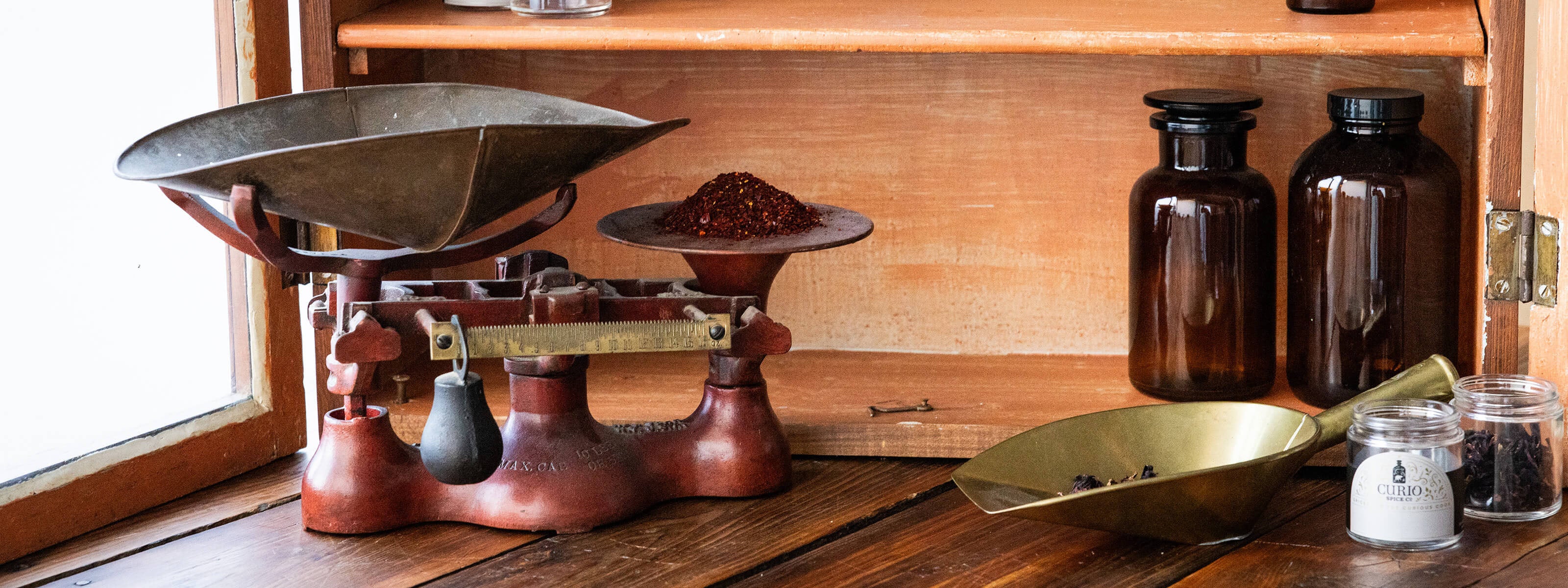 Vintage-style scale with brown bottles and containers on a wooden surface.