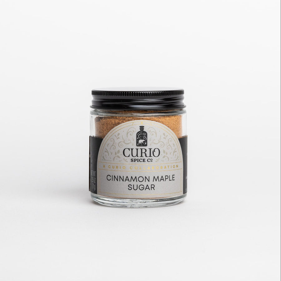 Jar of cinnamon maple sugar with Curio Spice Co. label on a white background