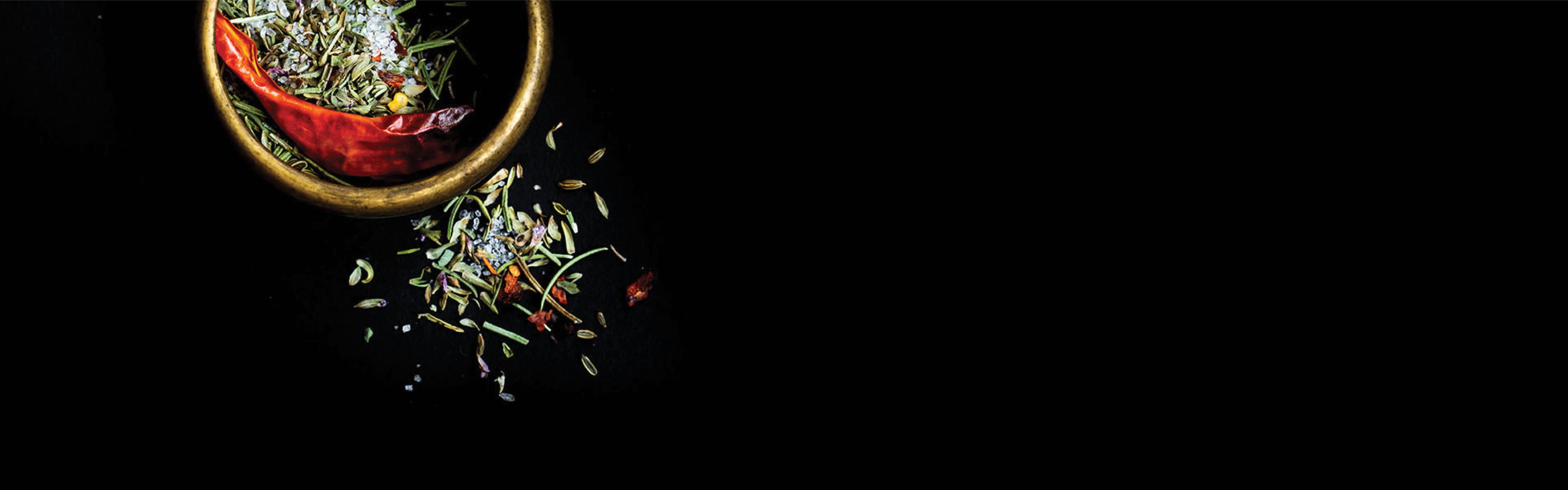 Spices in a red bowl on a black background