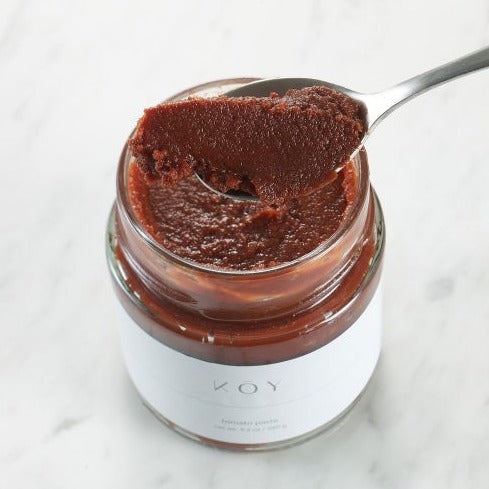 Koy Pantry open jar with spoon scooping tomato paste