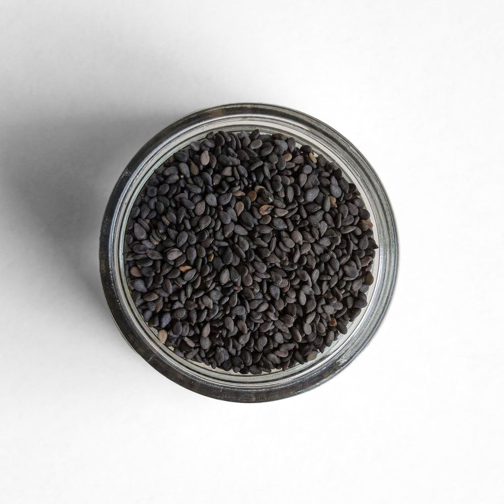 Curio Spice Co. fair-trade single origin sustainable black sesame seeds in a glass jar from above.